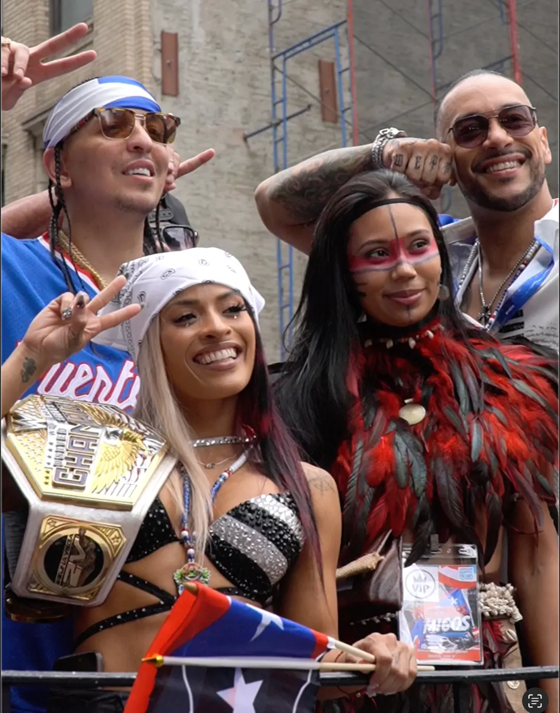 Group posing with a championship belt on a parade float