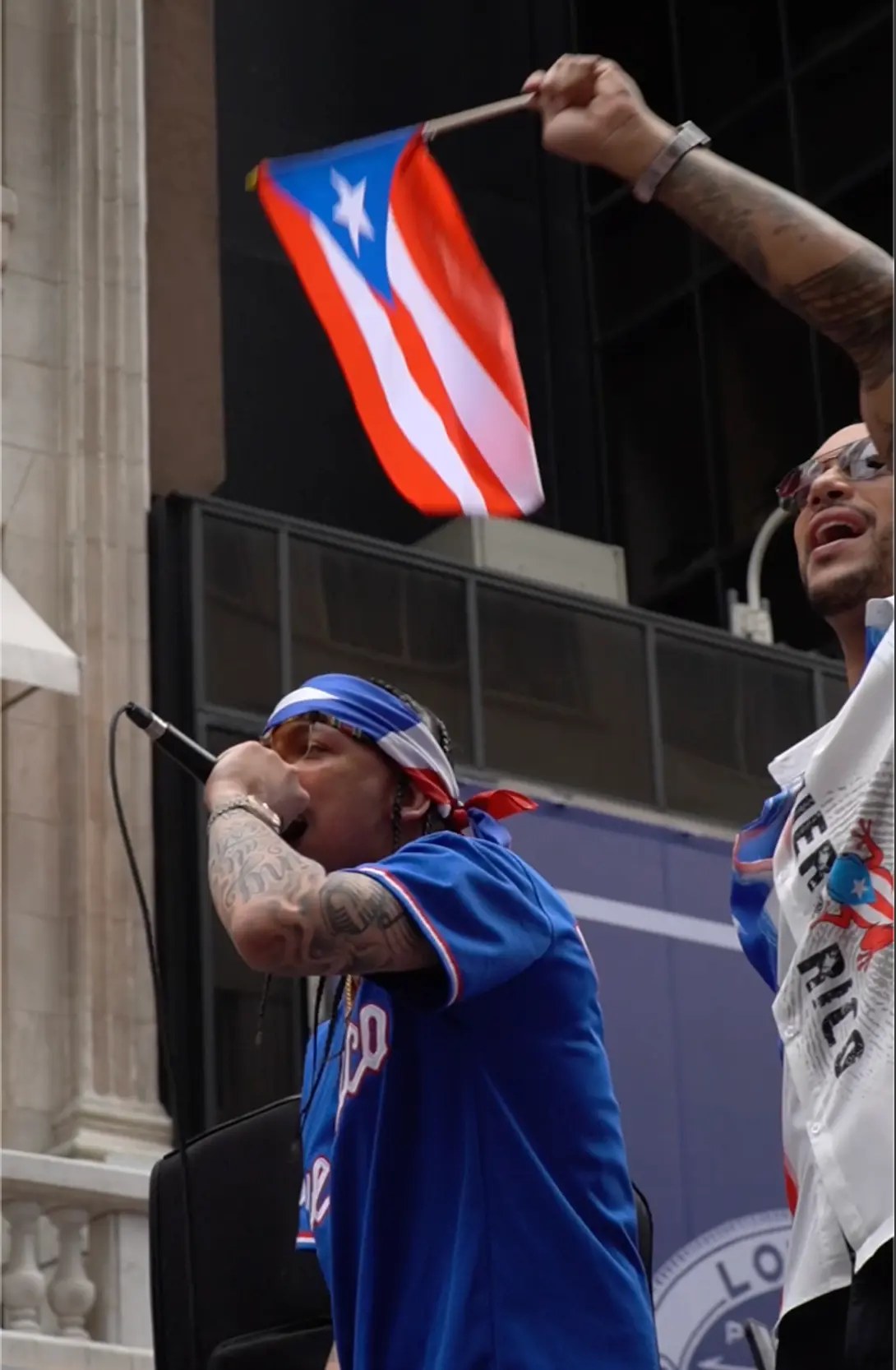 Artist performing with a Puerto Rican flag during a live parade set