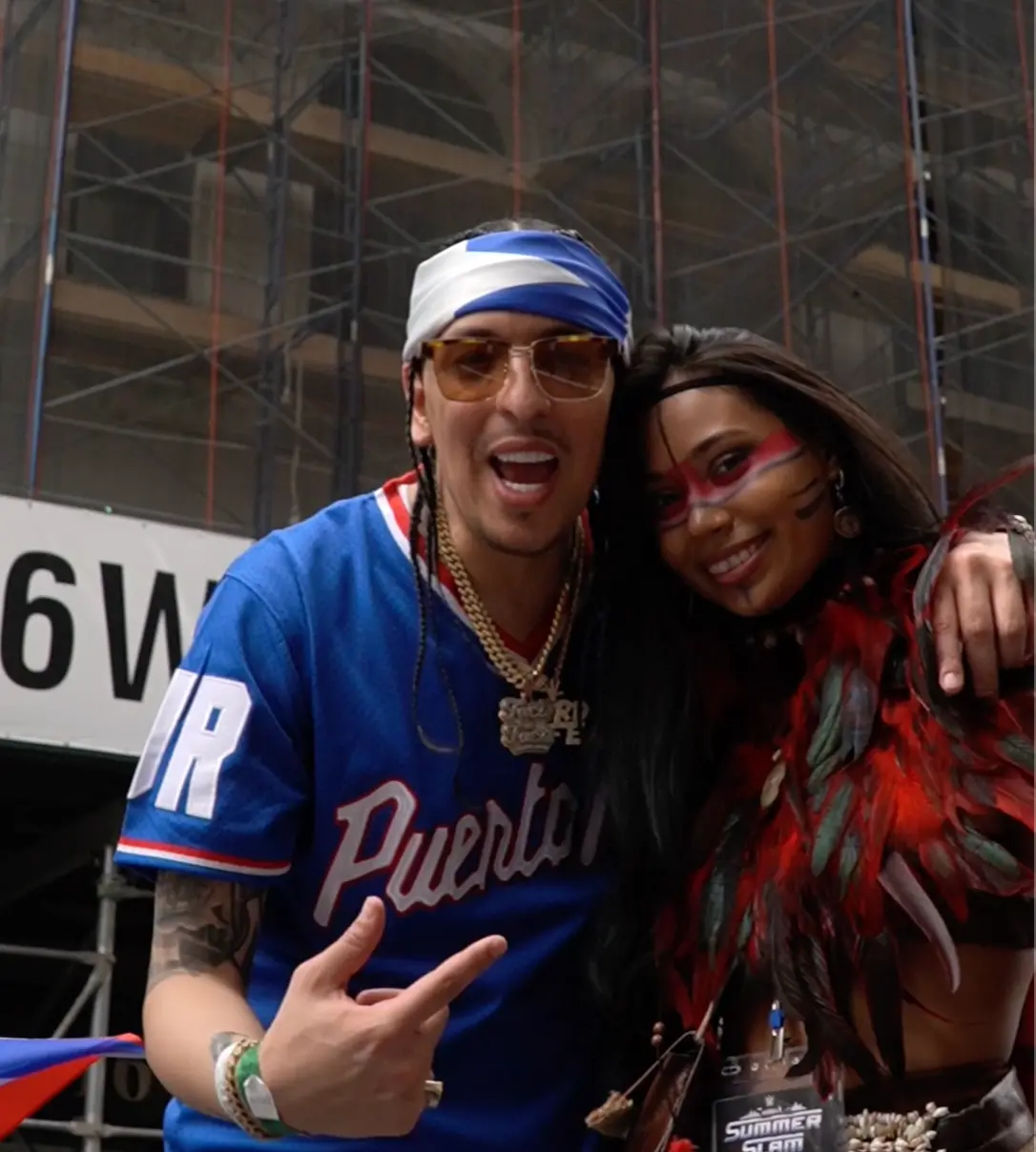 Artist posing with a performer in feathered festival attire