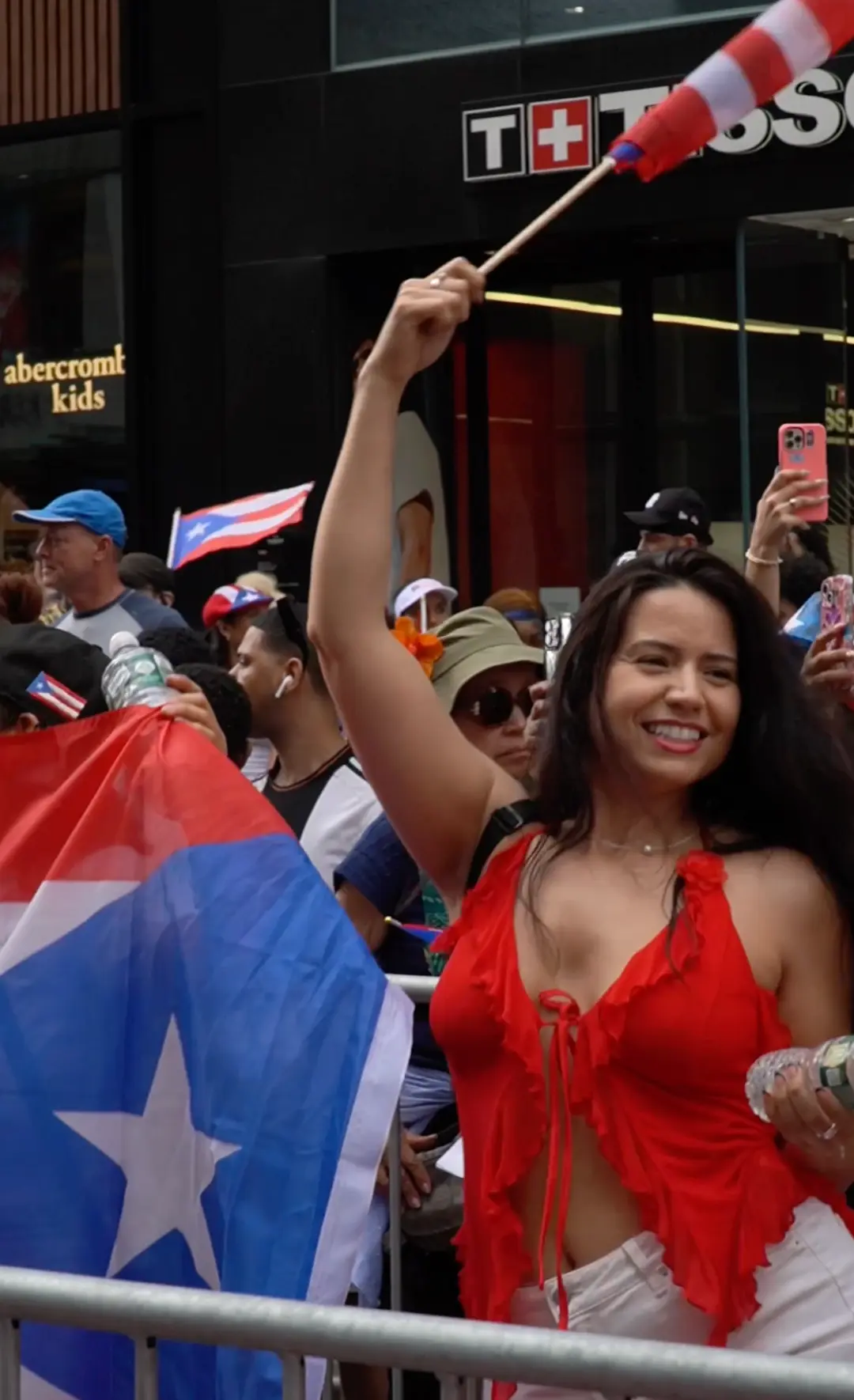 Parade attendee waving a Puerto Rican flag in the crowd