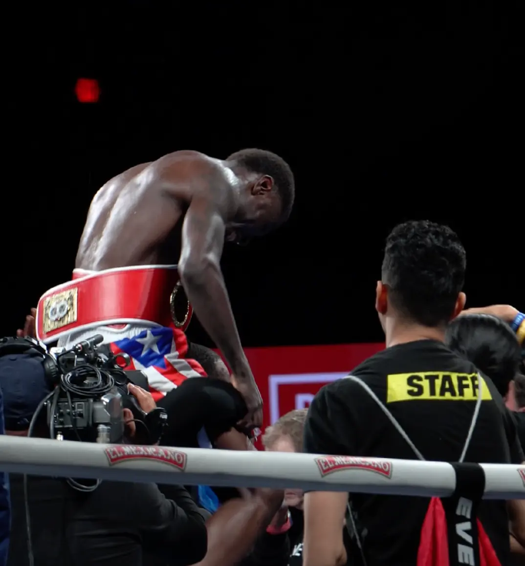 Boxer celebrating with the championship belt after the fight