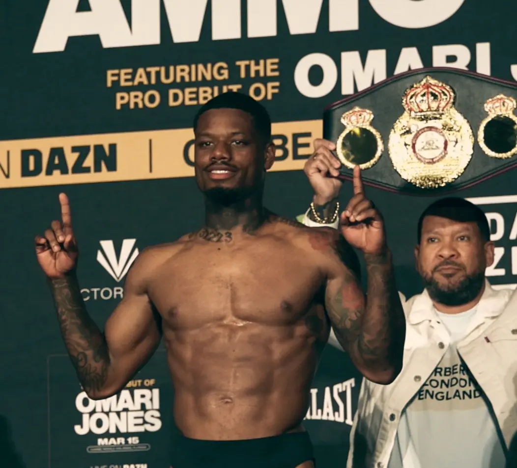 Champion posing with the title belt at the weigh-in