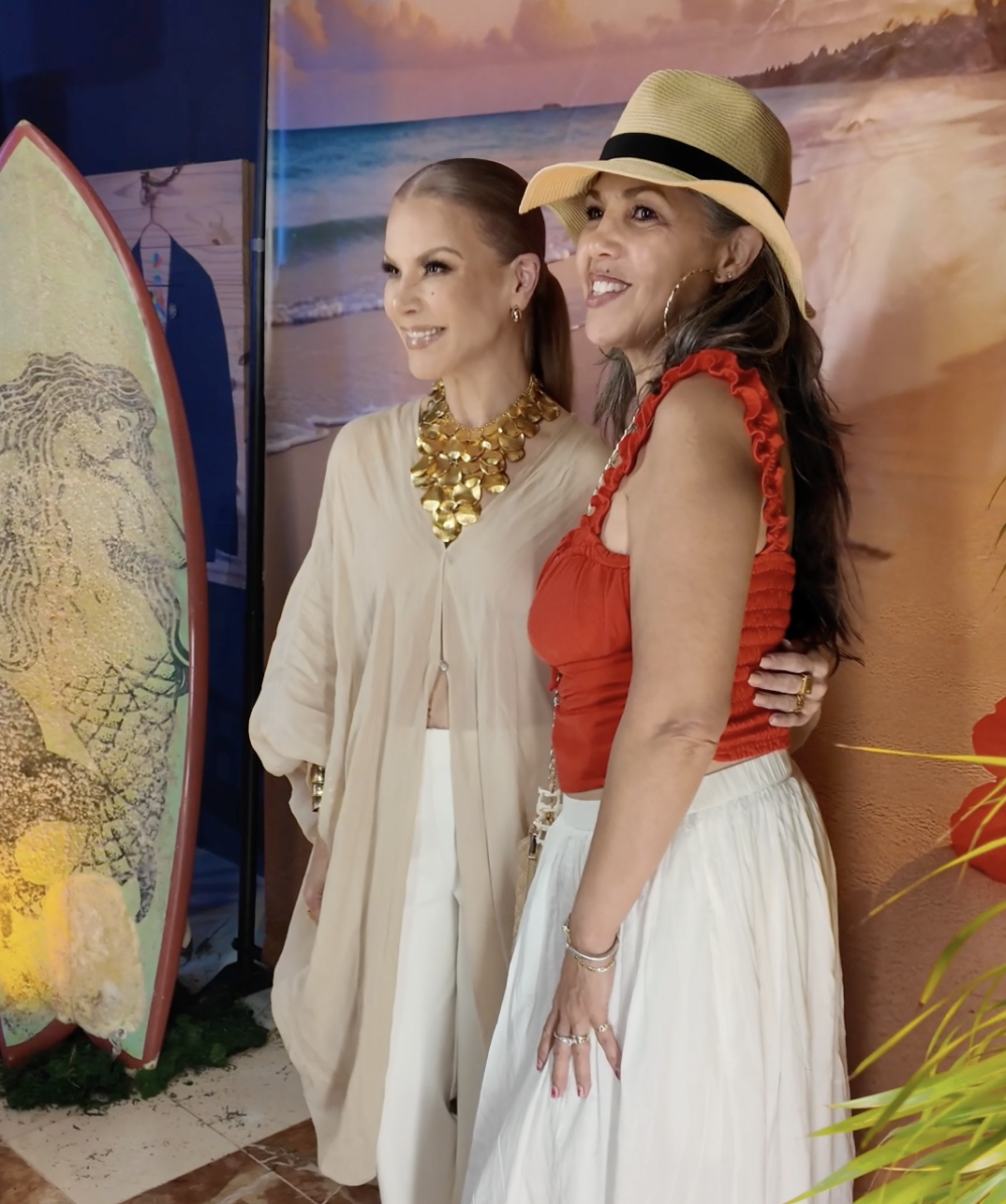 Guests posing together at a tropical-themed event backdrop
